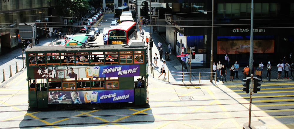 Tram, Buses, and Pedestrians in Hong Kong by Ka Ho Ng on Unsplash