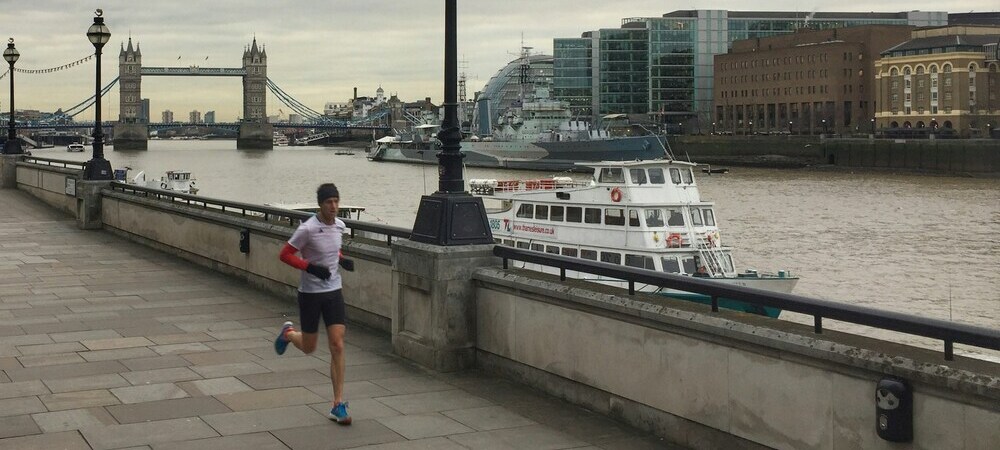 A runner next to the river Thames with the Tower Bridge in the background by Mark Saxby