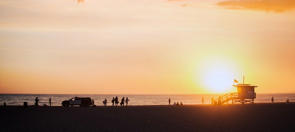 Beachgoers at sunset enjoying the warm weather in Los Angeles