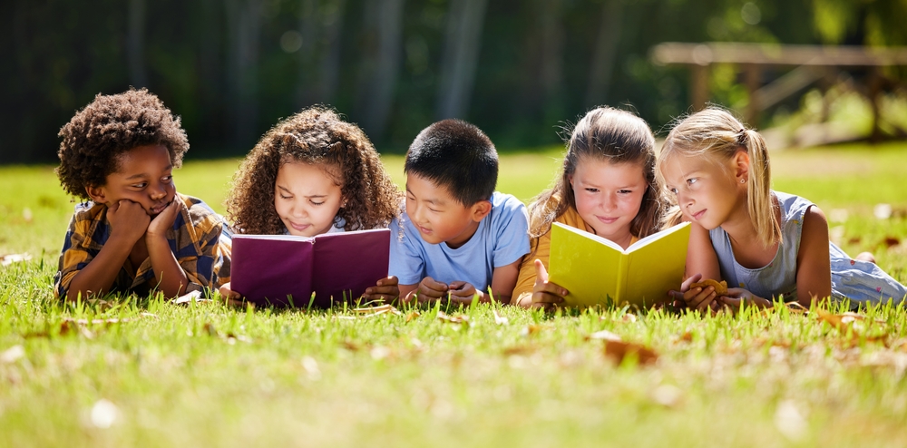 group of children reading in a field