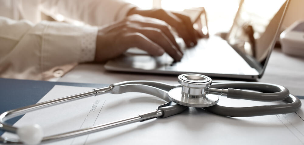healthcare professional using a laptop