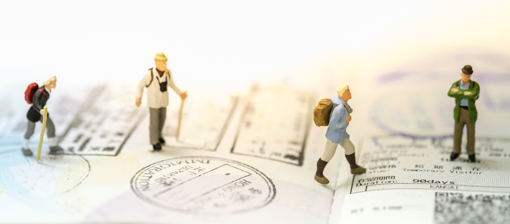 Miniature figures of travellers on passport page